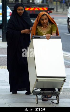 Deux femmes qui ont un frigo sur Bow Rd, East London. Banque D'Images