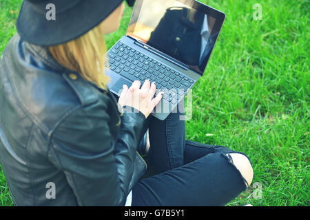 Hipster girl sitting avec ordinateur portable à la main, vue d'en haut Banque D'Images