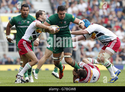 Le Dan Leo (au centre) de London Irish est abordé par Nick Evans (à gauche) de Harlequins lors du match Aviva Premiership à Twickenham, Londres. Banque D'Images