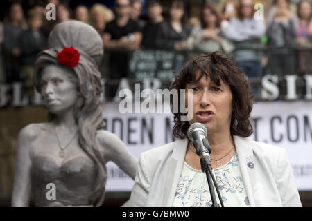 Janis Winehouse, la mère de feu Amy Winehouse, se trouve à côté d'une statue de sa fille, comme elle fait un discours, après son dévoilement sur ce qui aurait été le 31e anniversaire de la chanteuse, au marché stables, Camden Town, Londres. Banque D'Images