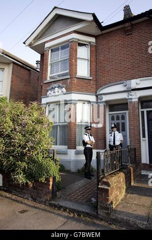 Deux policiers sont en garde devant le 4 Kenilworth Road, dans la région de Polygon à Southampton, après leur opération anti-terroriste Avon plus tôt dans la journée qui a abouti à l'arrestation de quatre hommes en vertu de la loi sur le terrorisme. Les résidents de Kenilworth Road regardaient la police en train d'émeute avec des mitrailleuses qui éclatent à travers l'avant de la propriété victorienne, qui est divisée en appartements, puis ont mené les quatre hommes asiatiques. Banque D'Images