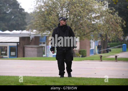 Un policier patrouille le terrain de la Mount Pleasant Primary School à Newport avant la visite du Premier ministre David Cameron et du président américain Barrack Obama. Banque D'Images