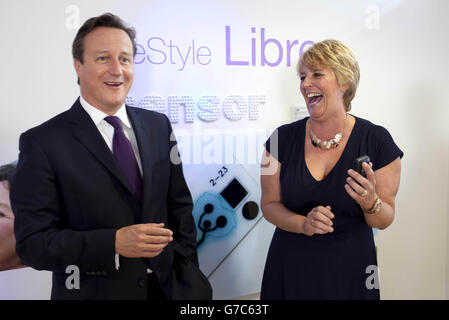 Le Premier ministre David Cameron rencontre Allison Jackson, un patient atteint de diabétesde type 1 lors d'une visite au laboratoire Abbott Diabetes Care de Witney, dans l'Oxfordshire, pour découvrir une nouvelle technologie de surveillance du glucose appelée FreeStyle libre. Banque D'Images