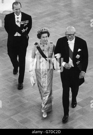 La reine Elizabeth II est escortée par le président finlandais Urho Kekkonen à un banquet d'État au Palais présidentiel le premier jour d'une visite de quatre jours en Finlande.Le duc d'Édimbourg suit. Banque D'Images