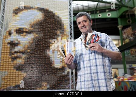 L'artiste Quentin Devine se dresse devant une toile de 24 mètres carrés, faite de 1,485 cartes postales de l'acteur Kiefer Sutherland de caractère comme Jack Bauer de la télévision 24, Exposé au Borough Market à Londres, qui a été utilisé comme lieu de tournage pour marquer la sortie Blu-ray et DVD de 24: Live Another Day le lundi 6 octobre. Banque D'Images