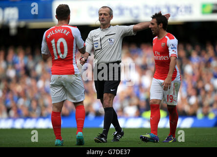 Jack Wilshere d'Arsenal et Santi Cazorla d'Arsenal (à droite) disputent avec l'arbitre Martin Atkinson lors du match de la Barclays Premier League à Stamford Bridge, Londres. Banque D'Images