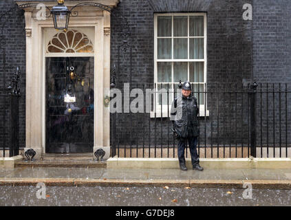 Un policier est sous une forte pluie à l'extérieur du 10 Downing Street, Londres. Banque D'Images