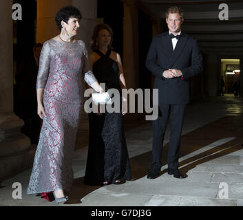 Le Prince Harry est accueilli par Mimi Drake (au centre), présidente des initiatives philanthropiques des 100 femmes dans les fonds de couverture, et Amanda Pullinger, directrice, lorsqu'il arrive pour leur dîner de gala à l'aide de l'organisme de bienfaisance Well Child au Royal Hospital Chelsea, à Londres. Banque D'Images