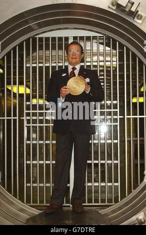 Sir Roger Moore demande aux photographes de Chatwood SAFE lors d'une séance photo de lancer l'appel de l'UNICEF « change for Good » à la succursale HSBC Poultry de la ville de Londres. La star de James Bond, qui est un ambassadeur de bonne volonté pour la charité des enfants depuis 1991, exhorte les gens à extraire leur ancienne monnaie européenne et à la remettre à l'une des 1,600 agences HSBC pour la campagne. Le coffre-fort a été présenté dans le film The Bond « Goldfinger ». Banque D'Images