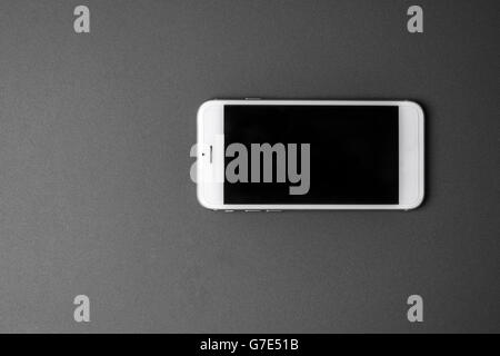 Smart phone en blanc sur fond gris Banque D'Images