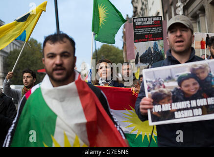 Les personnes manifestant près du pont de Westminster dans le centre de Londres avec des drapeaux et des bannières kurdes contre la menace de l'EI envers les minorités kurdes et autres en Syrie et en Irak. Banque D'Images