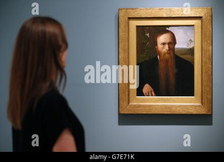 Un visiteur regarde un portrait de Sir Edward Burne-Jones, par Alphonse Legros, dans le cadre de l'exposition « anarchie et beauté » célébrant l'héritage de William Morris au National Portrait Gallery, Londres. Banque D'Images