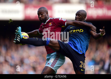 Carlton Cole de West Ham United (à gauche) et Eliaquim de Manchester City Mangala (à droite) lutte pour le ballon dans les airs Banque D'Images