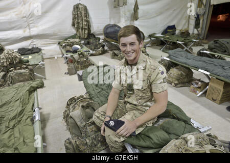 Le Caporal Thomas Warner 23, de Port Talbot de la 1re Garde de Dragoon de la Reine, est assis à l'intérieur d'un logement provisoire au Camp Bastion, tandis que les troupes se préparent à se retirer du camp de la province de Helmand, en Afghanistan, et à retourner au Royaume-Uni. Banque D'Images