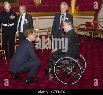 Le Prince Harry s'entretient avec le GC Jim Beaton et le Major Peter Norton GC (en fauteuil roulant) lorsqu'il arrive à l'accueil du Parti du Président dans les appartements de l'État du Palais St James's pour la Réunion royale de la Croix de Victoria et de l'Association de la Croix de George. Banque D'Images