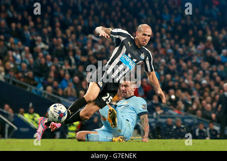 Gabriel Obertan, de Newcastle United, est confronté à un défi lancé par Aleksandar Kolarov, de Manchester City, dans la zone des peines, mais n'obtient pas la décision de l'arbitre Stuart Attwell lors du match du quatrième tour de la coupe Capital One au Etihad Stadium, à Manchester. Banque D'Images