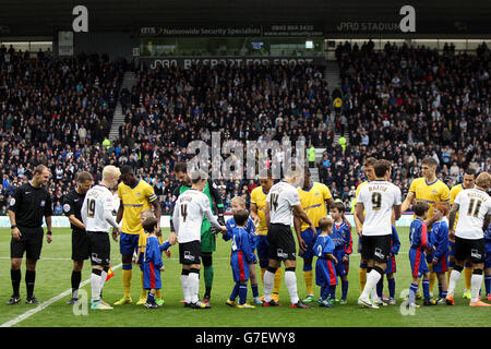 Les joueurs de Derby County et de Wigan Athletic se secouent les mains avant le jeu Banque D'Images