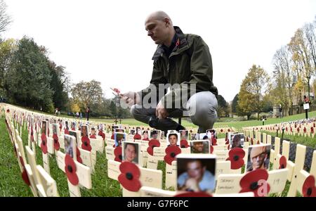 Mike Wilson, 27 ans, jette une croix pour son frère jumeau le caporal David Wilson, qu'il a perdu en Irak, car des milliers de croix poignantes en bois pour marquer les morts en Afghanistan et en Irak ont été posées dans un champ du souvenir à Saltwell Park, à Gateshead. Banque D'Images