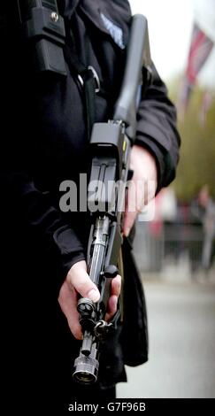 Un policier britannique armé se trouve sur la place du Parlement. Le Gouvernement a souligné la nécessité de lutter contre la menace que représente le terrorisme international dans le cadre de son prochain programme législatif. Les ministres ont mis en évidence les plans d'un projet de loi contre le terrorisme. Bien que le discours n'ait pas identifié de propositions précises, le projet de loi devrait probablement inclure des mesures controversées comme des procès sans jury pour des affaires terroristes et l'utilisation de preuves téléphoniques en cour pour la première fois. Banque D'Images