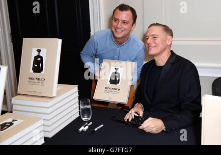 Singer a tourné le photographe Bryan Adams (à droite) comme un fan tient son nouveau livre, blessé: The Legacy of War, lors d'une visite privée des photographies incluses dans le livre, en présence du prince Harry, de jeunes militaires britanniques, hommes et femmes, qui ont subi des blessures mortelles en service militaire en Irak et en Afghanistan, intitulé, blessé: L'héritage de la guerre, à la Somerset House de Londres le jour de l'armistice - l'anniversaire de la fin de la première Guerre mondiale. Banque D'Images