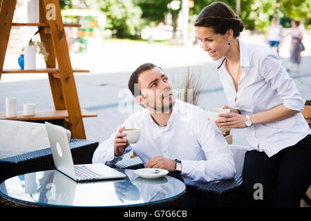 Des collègues travaillant sur leur pause au café Banque D'Images