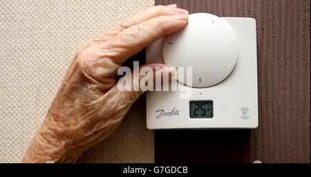 Une photo de stock générique d'une dame âgée qui règle son thermostat sur chez elle à Liverpool. Banque D'Images