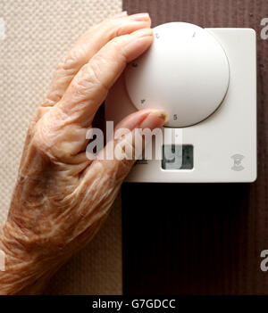 Une photo de stock générique d'une dame âgée qui règle son thermostat sur chez elle à Liverpool. Banque D'Images