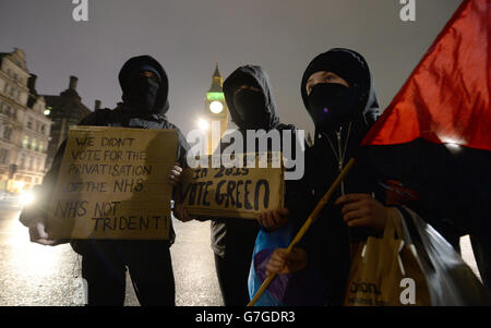 Les manifestants du groupe Occupy posent avec des placards lorsqu'ils tiennent une manifestation devant les chambres du Parlement de Londres. Banque D'Images