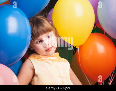 Portrait de studio de drôles de petits Caucasian blonde avec des ballons colorés sur fond de retour Banque D'Images