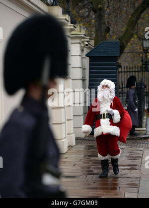 Un homme habillé comme Père Noël arrive au Palais St James' de Londres, où la princesse Royale a tenu une fête de Noël pour l'Association non oubliée. Banque D'Images