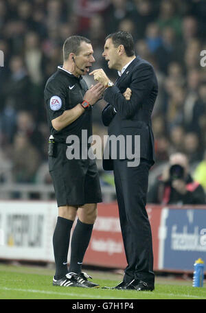 Gustavo Poyet, gérant de Sunderland (à droite), parle avec l'arbitre Kevin Friend lors du match de la première ligue de Barclays au Stade de Light, Sunderland. Banque D'Images