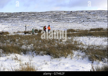 Les marcheurs traversent les chemins de Pennine au-dessus de Swaledale dans les Yorkshire Dales, tandis que le temps vivivivicié et hivernal se baladera dans toute la Grande-Bretagne cette semaine, suscitant la crainte de perturbations et de chaos dans les voyages. Banque D'Images