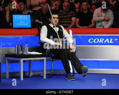 Ronnie O'Sullivan fléchit sa cheville endommagée alors qu'il est assis dans sa chaise lors de son deuxième match rond contre Peter Lines lors du championnat Coral UK 2014 au Barbican Center, York. Banque D'Images