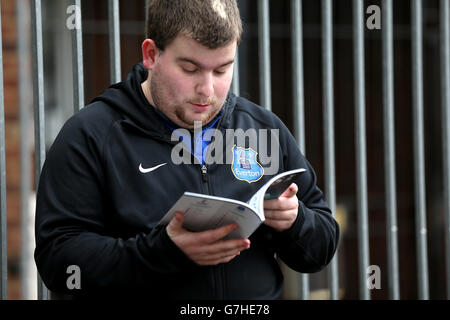 Football - Barclays Premier League - Tottenham Hotspur v Everton - White Hart Lane.Un fan d'Everton lit le programme de la journée de match Banque D'Images