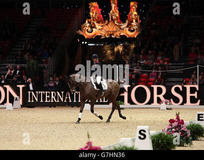 L'ancien cheval de course Kauto Star, monté par Laura Collett, se forme lors de la première journée du spectacle équestre international d'Olympia London au centre d'exposition d'Olympia, à Londres. Banque D'Images