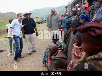 Le prince Harry danse devant les garçons du troupeau avec le prince Seeiso du Lesotho (en chapeau) lors d'une visite à une école de nuit de garçon du troupeau construite par Sentebale à Maseru, au Lesotho. Banque D'Images