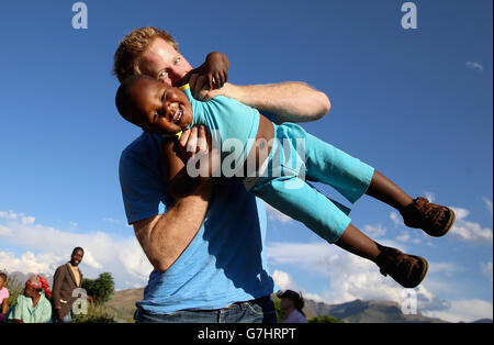 Le prince Harry balance un jeune orphelin de trois ans appelé Lerato sur cette photo prise avec l'aide d'une aveugle de trois ans appelée Karabo lors d'une visite au foyer pour enfants Phelisanong à Maseru, au Lesotho. Banque D'Images