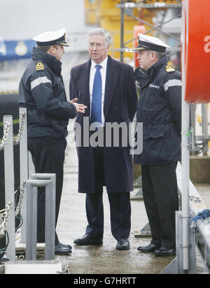 Le secrétaire à la Défense Michael Fallon (au centre) est photographié avec le commandant du HMS Triumph David Fillick (à gauche) et le commandant de la base navale Mark Adams (à droite) lors d'une visite à Faslane, officiellement connue sous le nom de HM Naval base Clyde, pour voir les progrès accomplis vers la transformation de la base en Centre sous-marin de spécialisation du Royaume-Uni. Banque D'Images