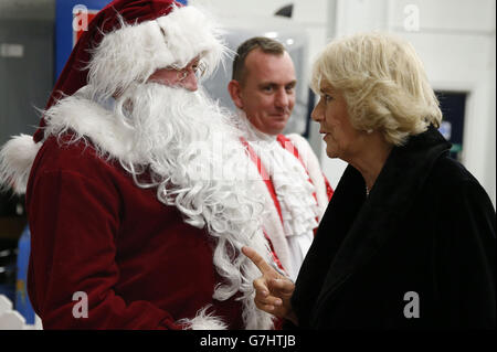 La duchesse de Cornwall rencontre un homme vêtu du père Noël, qui est l'un des interprètes, en coulisses lors de sa visite au salon international du cheval Olympia London 2014 au centre d'exposition Olympia. Banque D'Images