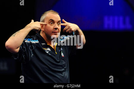 Phil Taylor réagit après avoir remporté la sixième série lors de son match avec Vincent van der Voort lors du championnat du monde des fléchettes William Hill à Alexandra Palace, Londres. Banque D'Images