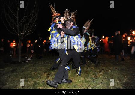 Des membres des danseurs Hook Eagle Morris dansent à l'intérieur du Vaughan Millennium Apple Orchard pendant un « Wassail » à Hartley Wintney, Hampshire. Banque D'Images