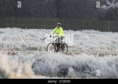 Un cycliste se déplace à Bushy Park, dans le sud-ouest de Londres, où les températures à proximité ont plongé en dessous de -4C. Banque D'Images