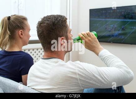 Couple watching football américain à la télévision. Banque D'Images