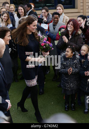 La duchesse de Cambridge recevant des fleurs d'élèves alors qu'elle quitte l'école primaire de Barlby à Londres, Après sa visite pour nommer officiellement la salle d'art Clore - une organisation caritative nationale qui offre l'art comme thérapie aux enfants et aux jeunes âgés de 5 à 16 ans qui sont confrontés à des défis dans leur vie. Banque D'Images