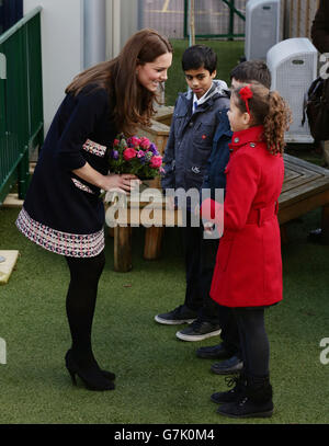 La duchesse de Cambridge recevant des fleurs d'élèves alors qu'elle quitte l'école primaire de Barlby à Londres, Après sa visite pour nommer officiellement la salle d'art Clore - une organisation caritative nationale qui offre l'art comme thérapie aux enfants et aux jeunes âgés de 5 à 16 ans qui sont confrontés à des défis dans leur vie. Banque D'Images