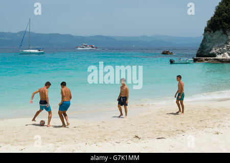 Groupe de jeunes hommes jouent au football sur la plage de sable magnifique Vrika, sur la petite île Antipaxos, îles Ioniennes, Grèce, Europe Banque D'Images