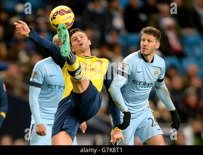 Olivier Giroud d'Arsenal lutte pour le ballon avec Martin Demichelis de Manchester City (à droite) lors du match de la première ligue de Barclays au Etihad Stadium de Manchester. Banque D'Images