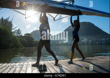 RIO DE JANEIRO - le 22 mars 2016 : Après la formation, deux rameurs brésilien porter leur bateau dans le clubhouse à Lagoa. Banque D'Images