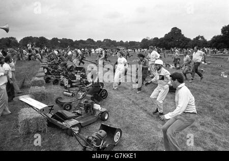 Action de la compétition de tondeuses à gazon, où les concurrents se font la course sur des tondeuses à gazon modifiées. Stirling Moss, pilote de course britannique, est photographié en deuxième à droite. Banque D'Images