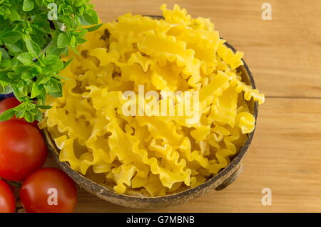 Pâtes farfalle papillon dans un bol avec des légumes sur la table Banque D'Images